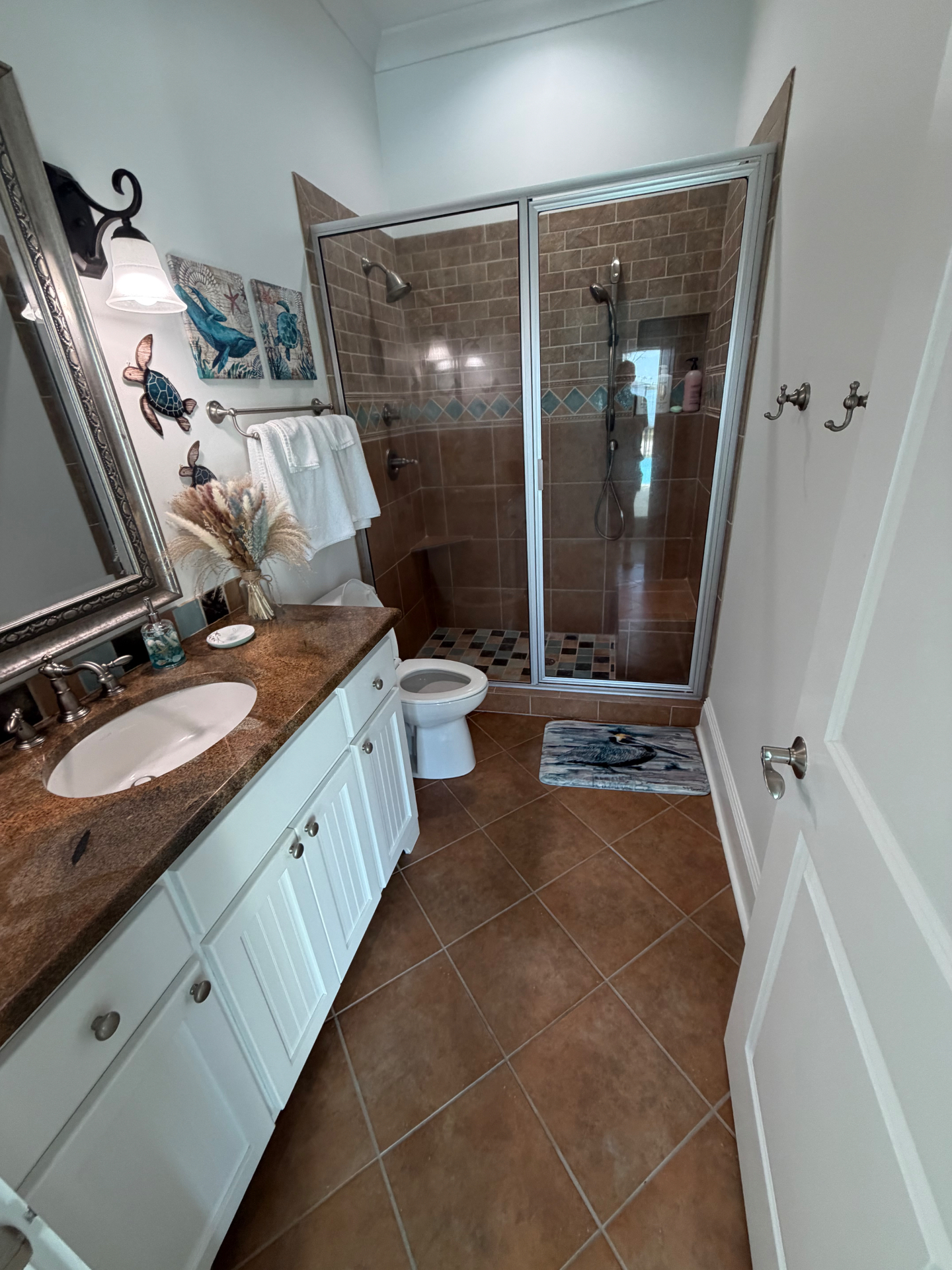 Coastal-themed bathroom with tile shower