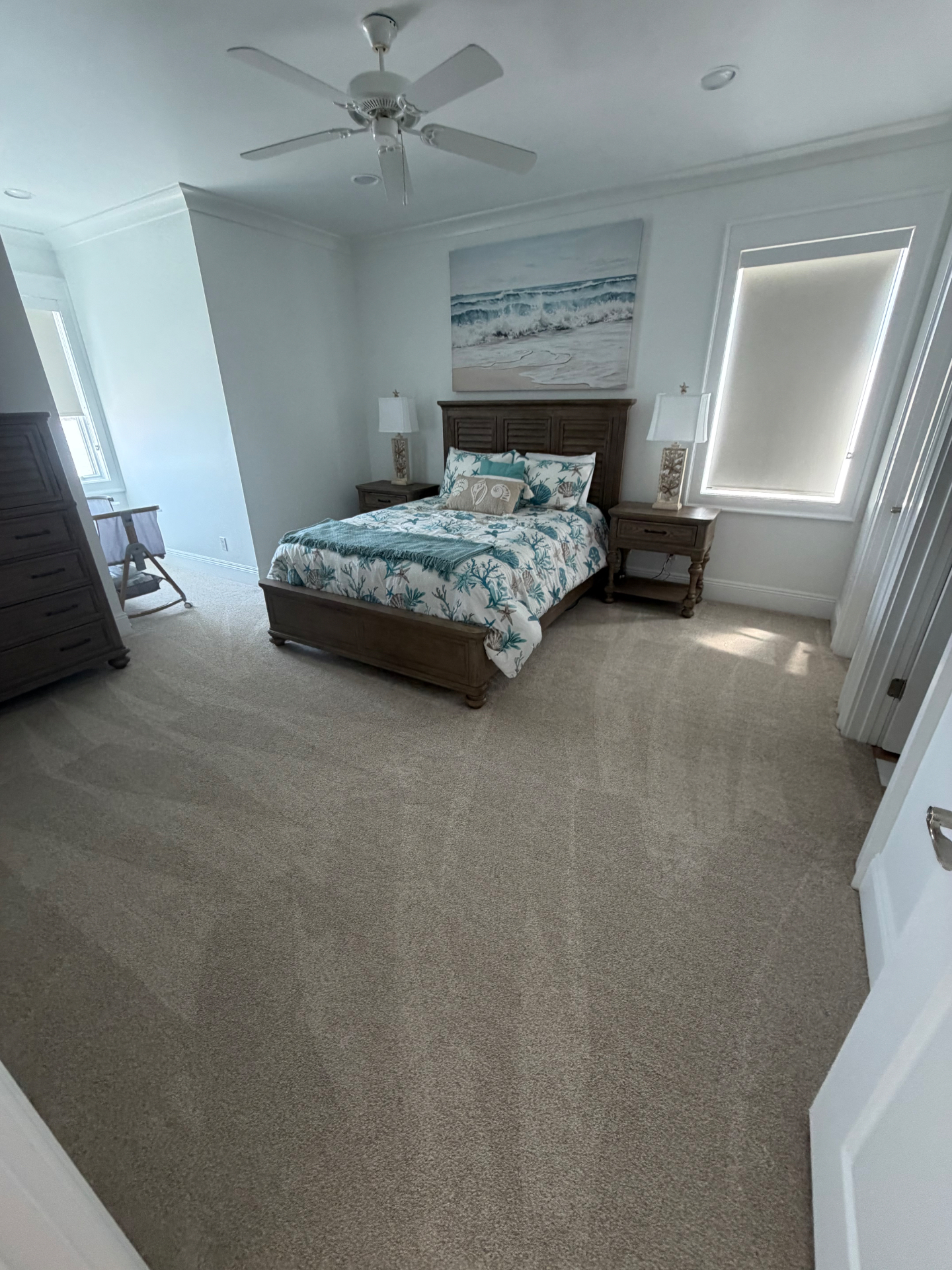 Freshly vacuumed coastal bedroom with beach-themed bedding