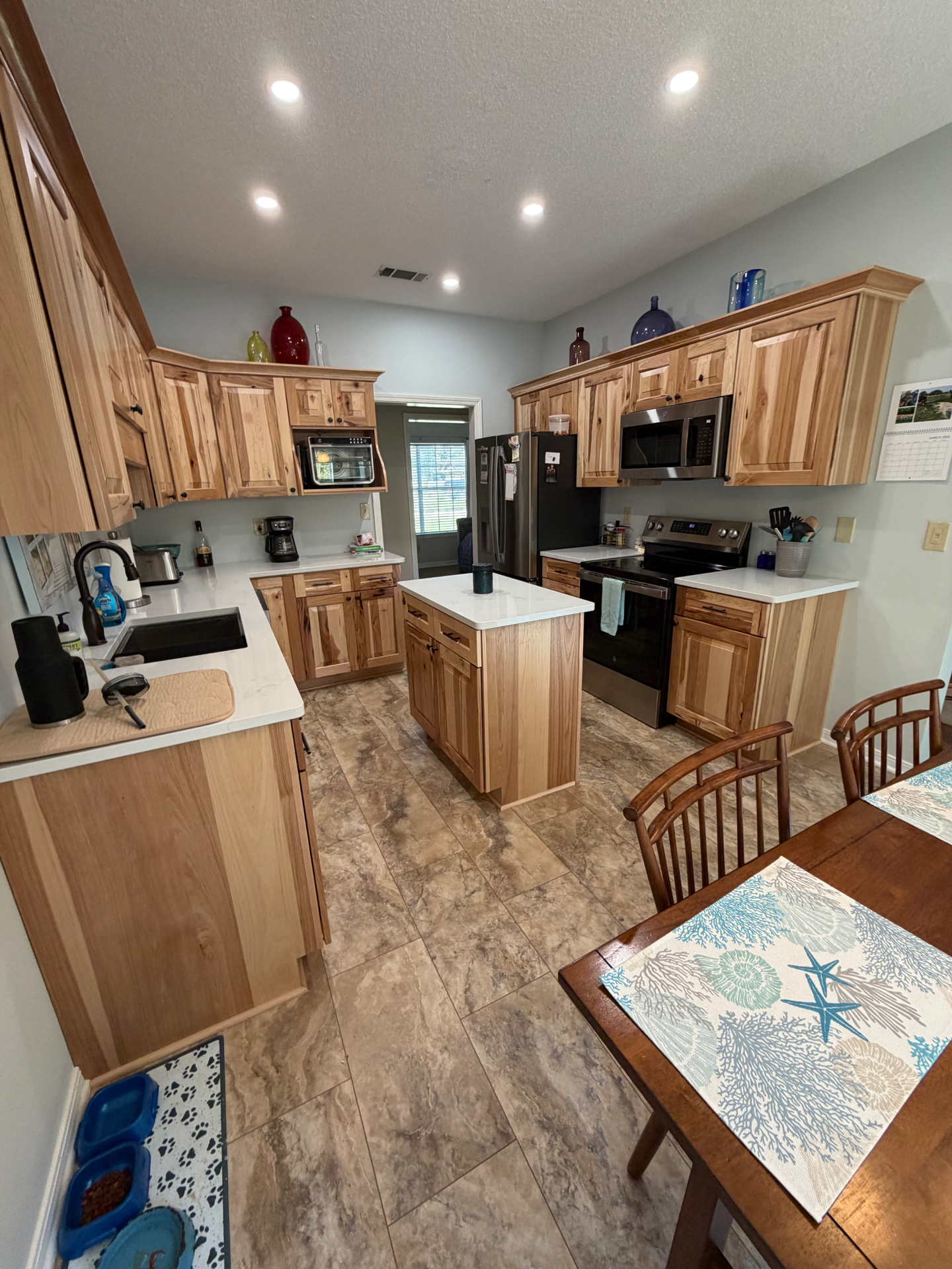 Spacious kitchen with hickory cabinets and coastal accents